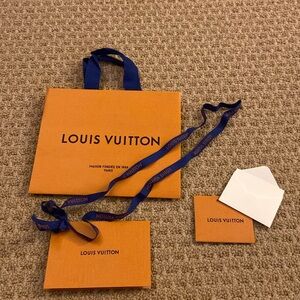 Louis Vuitton shopping bag, receipt envelope, ribbon and note/tag card.